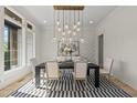 Chic dining room with modern light fixture, accent wall, and striped rug at 7417 Dover Hills Dr, Wake Forest, NC 27587