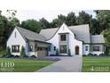 Beautiful white brick home featuring a curved roofline and attached garage on a manicured lawn with mature trees at 791 Chapel Ridge Dr, Pittsboro, NC 27312