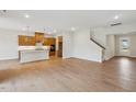 Open-concept living space with hardwood floors, recessed lighting, and a view into the modern kitchen at 208 Regency Ridge Dr, Holly Springs, NC 27540