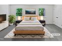 Staged bedroom with artwork, soft lighting, and light colored comforter at 104 Mossbark Ln, Chapel Hill, NC 27514