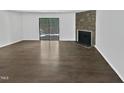 Open living room with stone fireplace and sliding glass doors at 104 Mossbark Ln, Chapel Hill, NC 27514