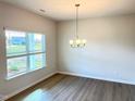 Bright dining room featuring vinyl flooring, a classic chandelier, and abundant natural light at 116 Bristow Ct # 49, Four Oaks, NC 27524