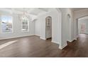 Elegant dining area showcasing hardwood floors, custom cabinetry, arched doorways, and a stylish chandelier at 125 Bold Dr, Youngsville, NC 27596