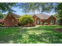 Brick home with landscaped lawn and mature trees at 7220 Dime Dr, Raleigh, NC 27606