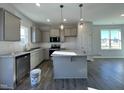 Modern kitchen with gray cabinets, granite countertops, and stainless steel appliances at 298 Springtooth Dr, Zebulon, NC 27597