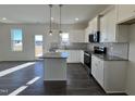 Modern kitchen features white cabinets, stainless steel appliances, and a granite countertop island at 356 Springtooth Dr, Zebulon, NC 27597