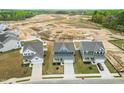 An aerial view showcases the neighborhood and highlights the blue two-story home at 8905 Stratus St, Willow Springs, NC 27592