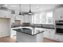 Modern kitchen with white cabinets, black countertops, and a large island at 5017 Trotter Dr, Raleigh, NC 27603