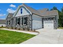 Beautiful two-story home featuring stone accents, a two-car garage, and well-maintained lawn at 135 Ironwood Blvd # 49, Youngsville, NC 27596