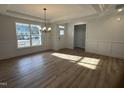 Bright living room featuring hardwood floors, stylish chandelier and large window at 135 Ironwood Blvd # 49, Youngsville, NC 27596