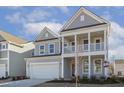 Two-story house with gray siding, white columns, and a two-car garage at 18 Steppe Way, Garner, NC 27529