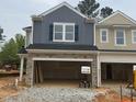 New two-story townhouse showcasing stone accents, siding, and open garage space in a residential neighborhood at 136 Malbec Dr, Chapel Hill, NC 27516