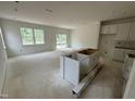 Spacious living room with ample natural light, bare concrete floors, and rough in for kitchen appliances at 136 Malbec Dr, Chapel Hill, NC 27516