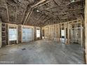 Unfinished living room shows framing and insulation, windows for natural light, and high, vaulted ceilings at 1275 Cameron Hill Rd, Cameron, NC 28326