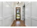 Inviting foyer featuring a modern front door, white wainscoting, hardwood floors, and contemporary lighting at 14020 Durant Rd, Raleigh, NC 27614