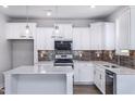 Modern kitchen featuring white cabinets, quartz countertops, and stylish light fixtures at 5828 Genesee Dr., Homesite 9, Durham, NC 27712