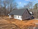 Beautiful aerial view of a white farmhouse with a dark roof and lush surroundings at 2817 Silk Hope Gum Springs Rd, Pittsboro, NC 27312