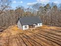 Beautiful aerial view of a white farmhouse with a dark roof and lush surroundings at 2817 Silk Hope Gum Springs Rd, Pittsboro, NC 27312