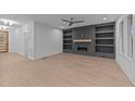 Open-concept living room with modern fireplace, custom shelving, and light hardwood floors at 5300 Pulley Town Rd, Zebulon, NC 27597