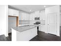 Modern kitchen features white cabinets, granite countertops, stainless steel appliances, and a center island at 289 Hank Way, Angier, NC 27501