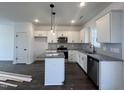 Modern kitchen with white cabinets, granite countertops, and a kitchen island at 149 Greenview St, Clayton, NC 27520