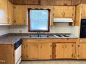 Kitchen features wood cabinets, double sink, and stove at 515 Cody St, Roxboro, NC 27573