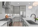 A kitchen with stainless steel appliances, quartz countertops and stylish gray cabinets at 227 Woodsborough Pl, Raleigh, NC 27601