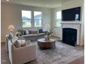 Bright living room featuring fireplace, plush seating, large windows offering plenty of natural light at 235 Chestnut Oak Ln, Lillington, NC 27546