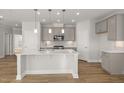 Modern kitchen with white cabinetry, quartz countertops, and stainless steel appliances at 103 W Star Foal Ln, Wendell, NC 27591