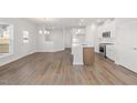 Open-concept living space with wood floors, connecting kitchen and dining areas at 22 Belmont Stakes Ln, Wendell, NC 27591