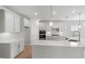 Bright kitchen featuring white cabinetry, a spacious island, stainless steel appliances, and modern pendant lighting at 75 E Star Foal Ln, Wendell, NC 27591