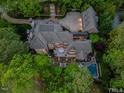 Aerial view of a large home with a pool, patio, and lush greenery at 50211 Manly, Chapel Hill, NC 27517