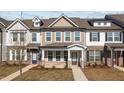Charming townhome with covered porch, brick accents, neutral siding, and well-maintained landscaping at 953 Alma Railway Dr, Wake Forest, NC 27587