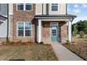 A close-up of a townhome entrance, showcasing stone detail and a teal front door at 959 Alma Railway Dr, Wake Forest, NC 27587