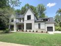 Elegant two-story home with a green lawn, stone accents, an attached garage, and a well-maintained landscape at 7208 Tanbark Way, Raleigh, NC 27615