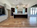Open kitchen design with a central island, hardwood floors, high ceilings, a pendant lights, and lots of natural light at 7208 Tanbark Way, Raleigh, NC 27615
