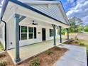 Welcoming covered front porch with classic columns, ceiling fans, and stylish black accents at 247 Jenkins St, Erwin, NC 28334