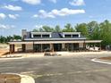 Modern clubhouse exterior showcasing a covered porch, stone accents and black framed windows on a sunny day at 191 Anise Ln, Garner, NC 27529