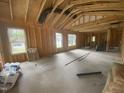 Unfinished living room with exposed wood framing, and a concrete floor ready for customization and finishing touches at 233 Jenkins St, Erwin, NC 28334