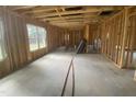 Unfinished living room showcasing exposed framing and a concrete slab, ready for design and personalization at 233 Jenkins St, Erwin, NC 28334
