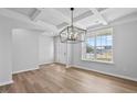 Bright dining room boasts elegant coffered ceilings, hardwood floors, and ample natural light at 2820 Lacy Holt Rd, Graham, NC 27253