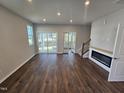 Bright living room with fireplace, hardwood flooring, recessed lighting, and glass doors to screened in porch at 1341 Bessie Ct, Wake Forest, NC 27587