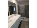 Bathroom featuring double sinks, gray tile flooring and a glass enclosed tile shower at 1343 Bessie Ct, Wake Forest, NC 27587