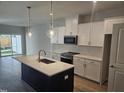 Modern kitchen with stainless appliances, subway tile backsplash, island and white cabinets at 1343 Bessie Ct, Wake Forest, NC 27587
