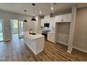 Modern kitchen featuring an island, stainless steel appliances, and sleek white cabinetry at 1345 Bessie Ct, Wake Forest, NC 27587