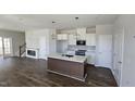 Open-concept kitchen featuring a center island, white cabinets, and stainless steel appliances at 1349 Bessie Ct, Wake Forest, NC 27587