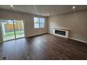 Bright living room with an electric fireplace and sliding glass door to the backyard at 1351 Bessie Ct, Wake Forest, NC 27587
