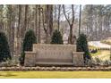 Stone entrance sign for Shadow Creek Estates is set among trees and plantings at 4804 Parker Meadow Dr, Raleigh, NC 27614