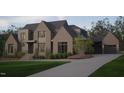 Elegant two-story brick home with a circular driveway, mature landscaping, and a three-car garage at 4905 Foxridge Dr, Raleigh, NC 27614