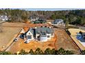 Aerial view of new traditional style home with gray brick, black trim, gray shake roof on an unfinished lot at 705 Parker Creek Dr, Raleigh, NC 27614